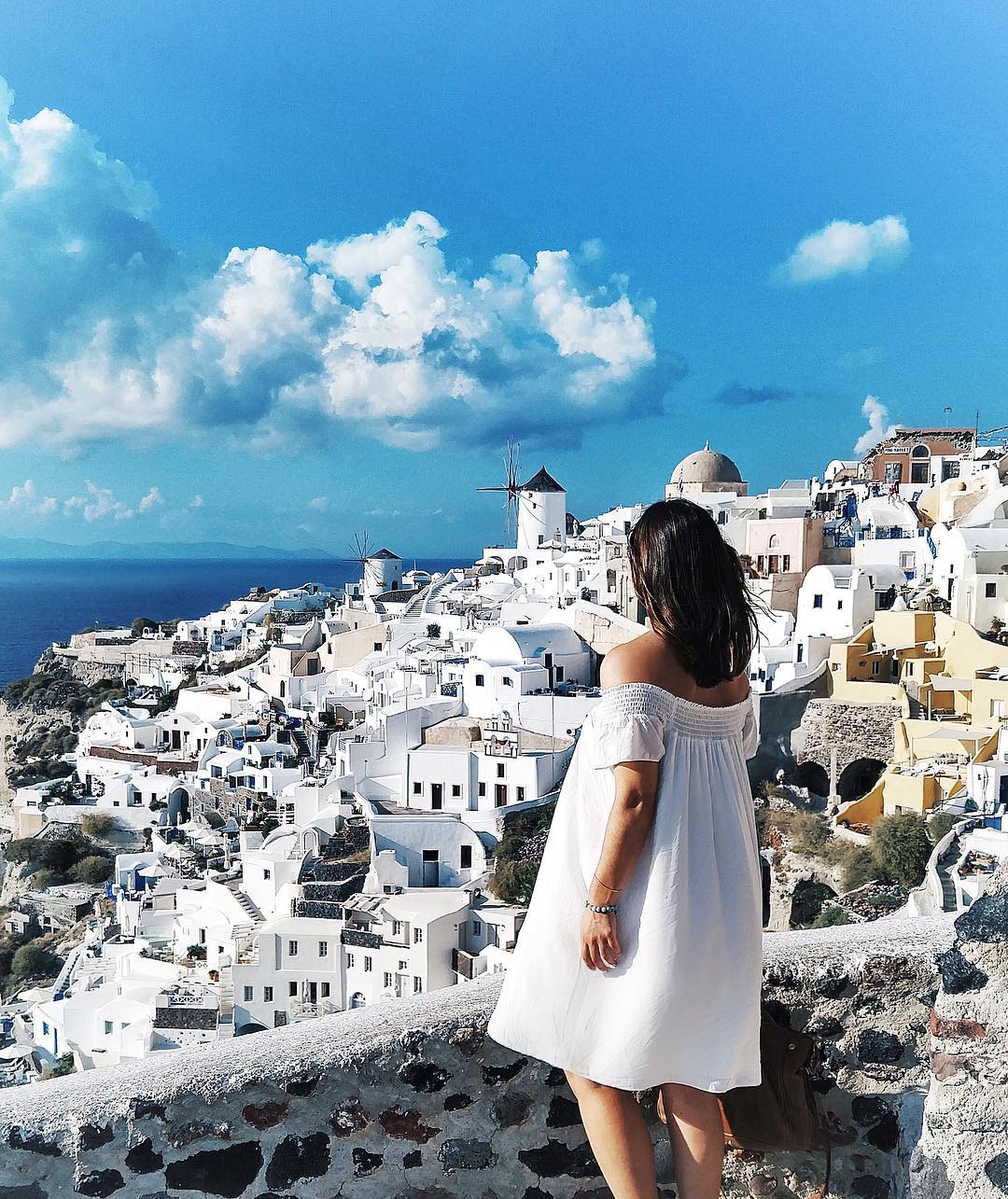 To Vogue or Bust in an Aritzia off the shoulder dress in Oia, Santorini, Greece