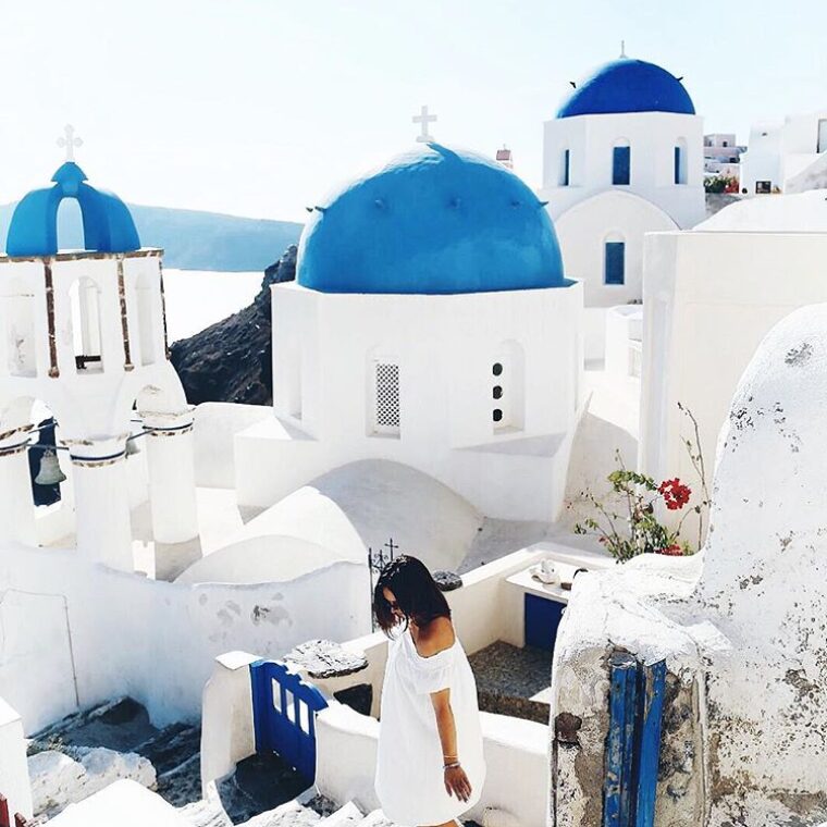 To Vogue or Bust wearing Aritzia off the shoulder dress in Oia, Santorini, Greece