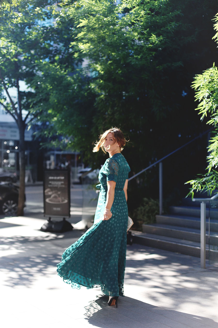 To Vogue or Bust shares what to wear to a black tie wedding in a green dotted Revole Tularosa dress, Ted Baker pink clutch and a low chignon.