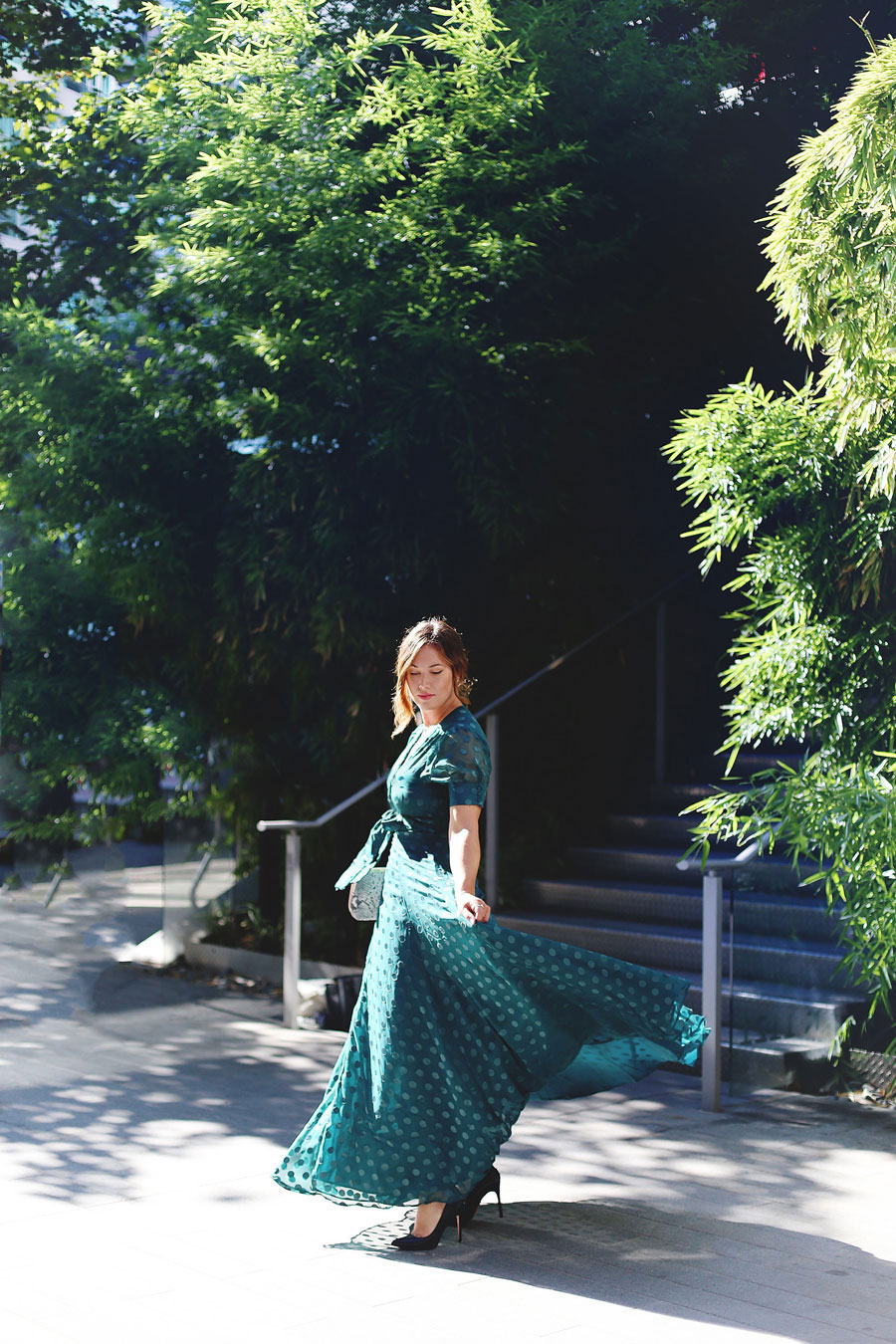 To Vogue or Bust shares what to wear to a black tie wedding in a green dotted Revole Tularosa dress, Ted Baker pink clutch, Leah Alexandra rings and Swarovski rings, and a low chignon.