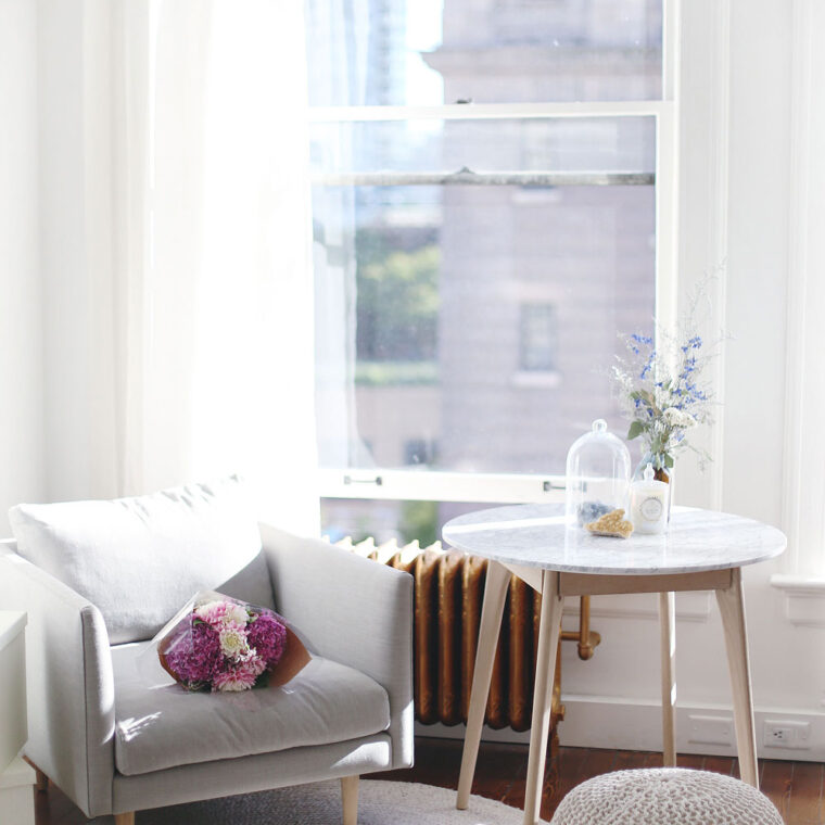 Airy studio space decor tips with marble coffee table, grey minimalist armchair, jute rug and Moroccan pouf by Article furniture