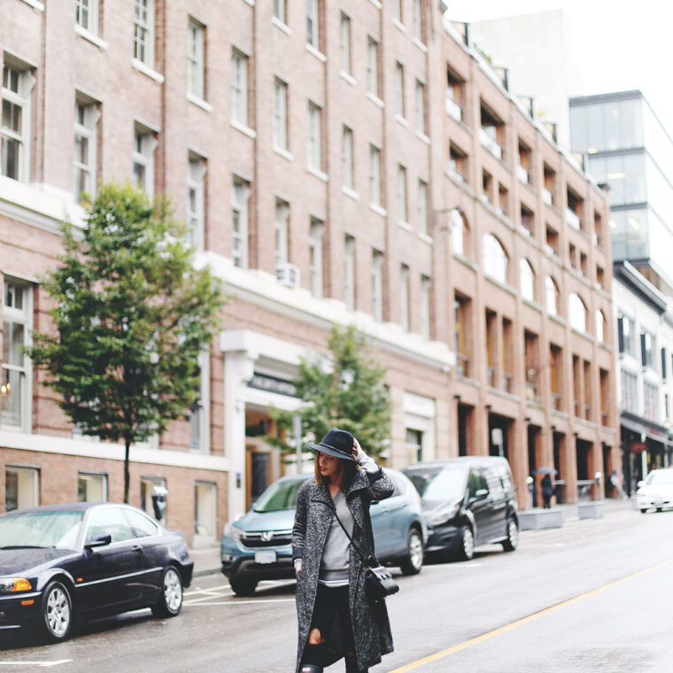 Rainy day outfit ideas for fall, featuring Aritzia Babaton wool trench coat, White and Warren cashmere sweater, striped tank top, Express black wool fedora, Mezzi Mini Cosma bag, Hunter rain boots