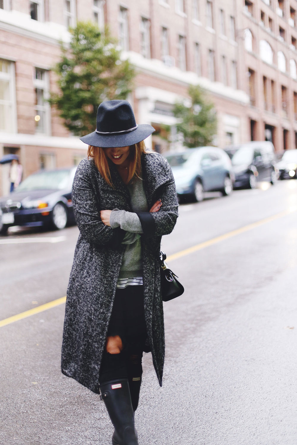 Rainy day outfit ideas for fall, featuring Aritzia Babaton wool trench coat, White and Warren cashmere sweater, striped tank top, Express black wool fedora, Mezzi Mini Cosma bag, Hunter rain boots