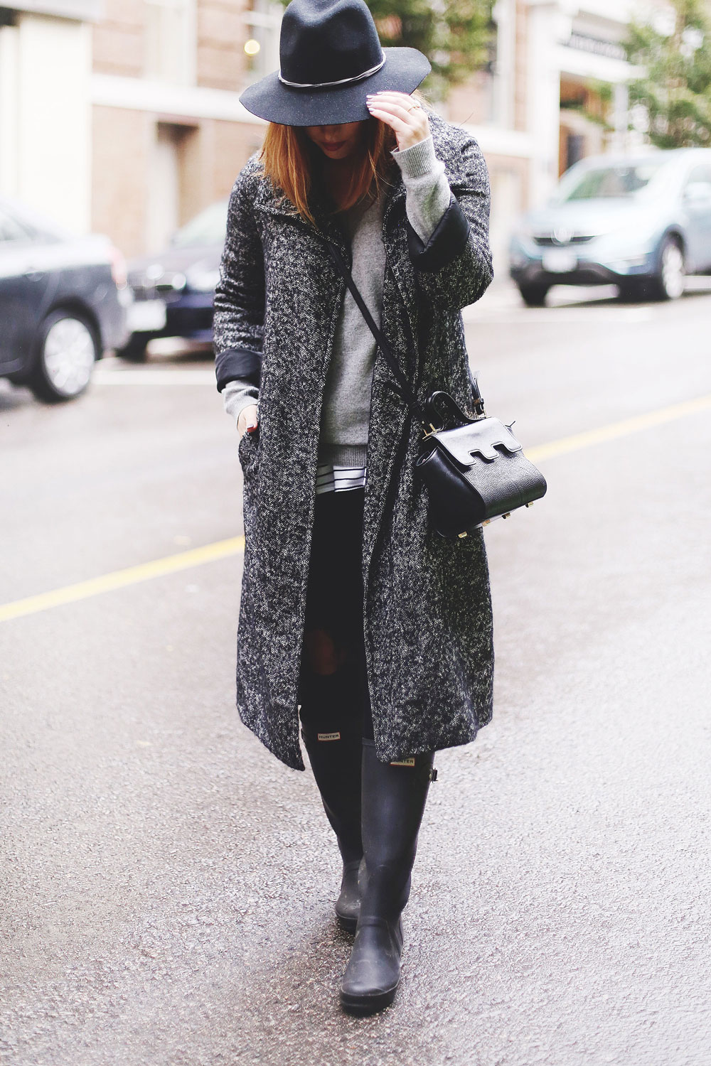 Rainy day outfit ideas for fall, featuring Aritzia Babaton wool trench coat, White and Warren cashmere sweater, striped tank top, Express black wool fedora, Mezzi Mini Cosma bag, Hunter rain boots