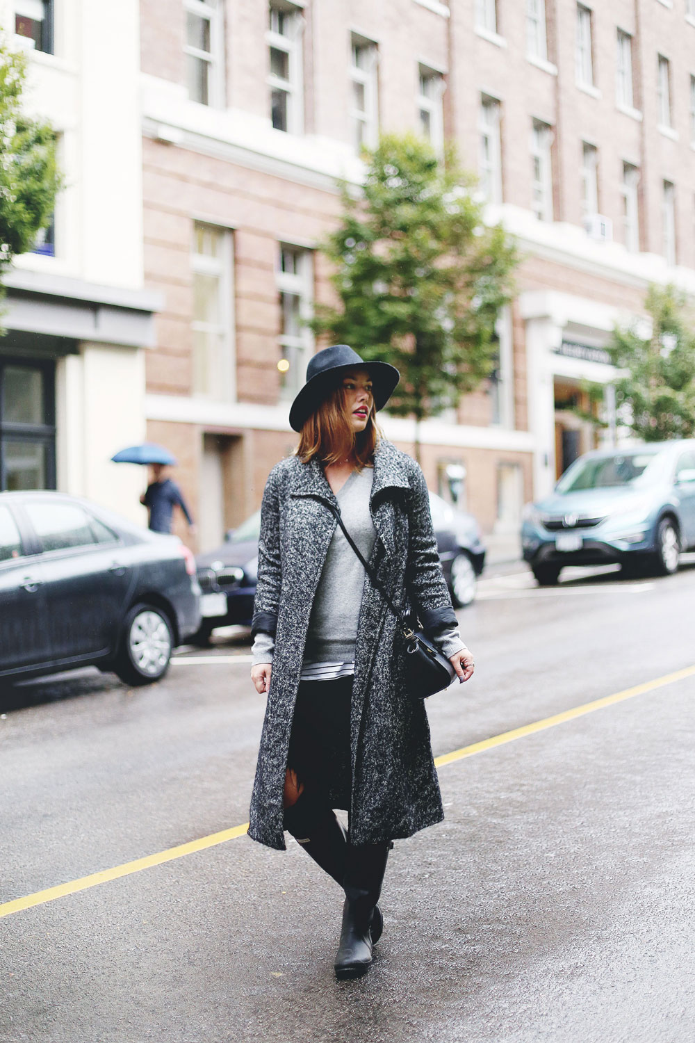 Rainy day outfit ideas for fall, featuring Aritzia Babaton wool trench coat, White and Warren cashmere sweater, striped tank top, Express black wool fedora, Mezzi Mini Cosma bag, Hunter rain boots