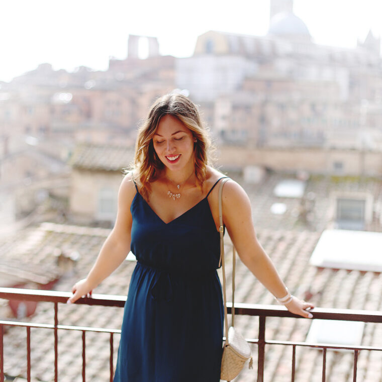 To Vogue or Bust shares jewelry stacking tips in Swarovski jewelry, Aritzia silk dress, Tieks flats and vintage Bottega Venata bag in Siena, Italy