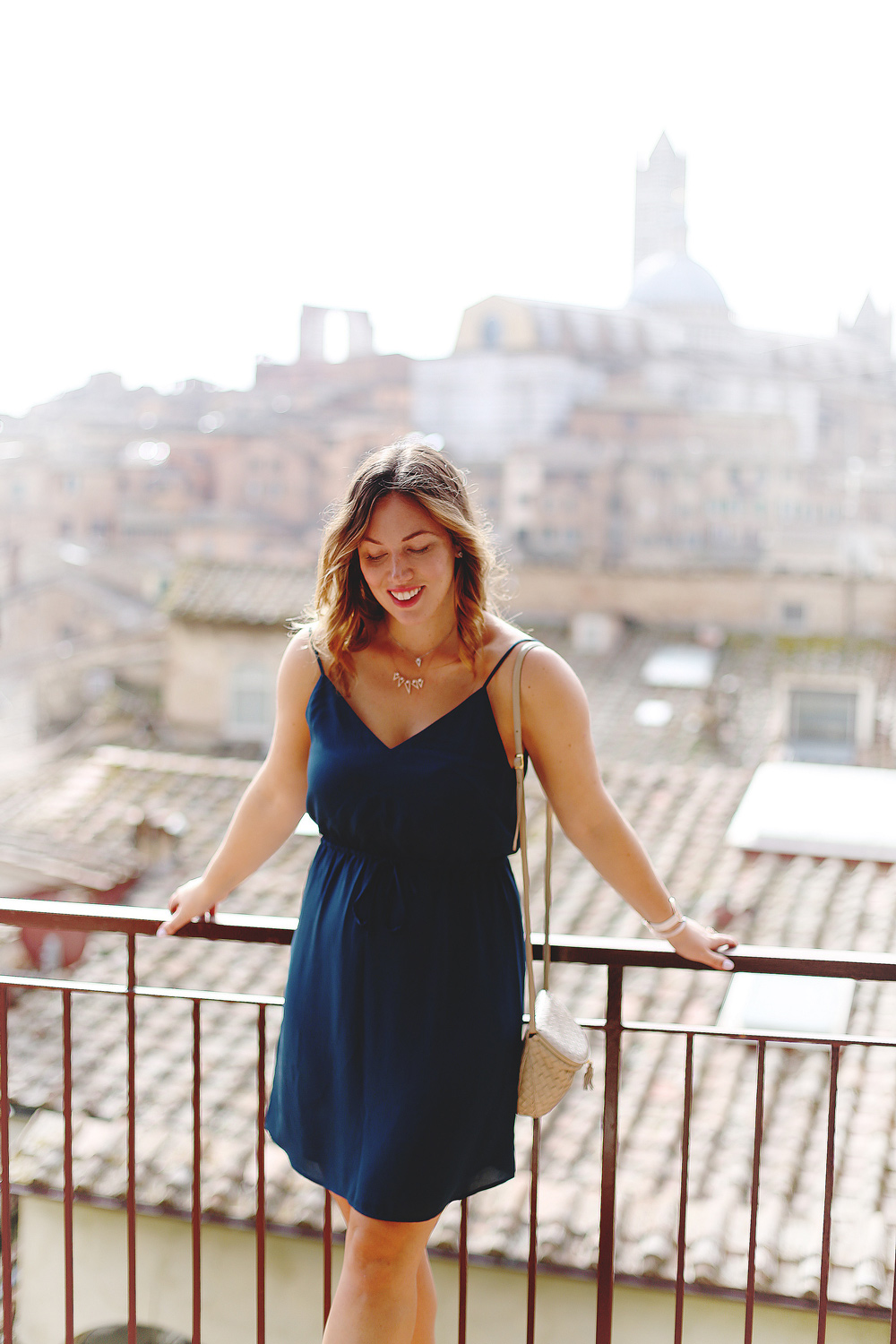 To Vogue or Bust shares jewelry stacking tips in Swarovski jewelry, Aritzia silk dress, Tieks flats and vintage Bottega Venata bag in Siena, Italy