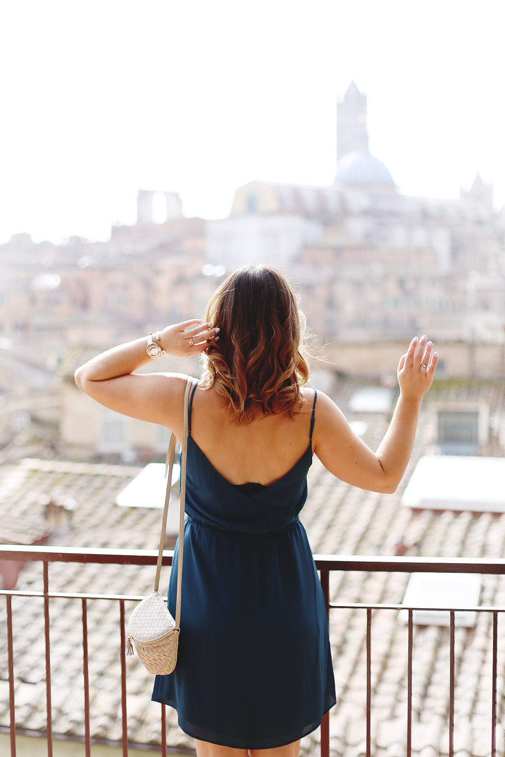 To Vogue or Bust shares jewelry stacking tips in Swarovski jewelry, Aritzia silk dress, Tieks flats and vintage Bottega Venata bag in Siena, Italy