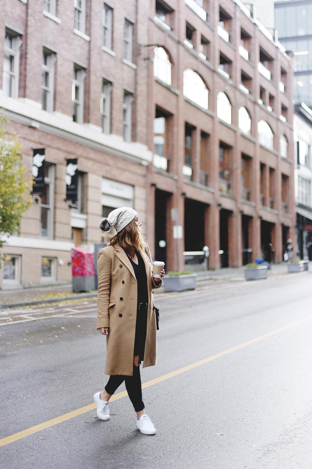 To Vogue or Bust shares ways to style your converse sneakers in white Converse All Stars, Aritzia camel coat, James Jeans black skinny jeans, Aritzia black leather bag and a Tilley Hats beanie