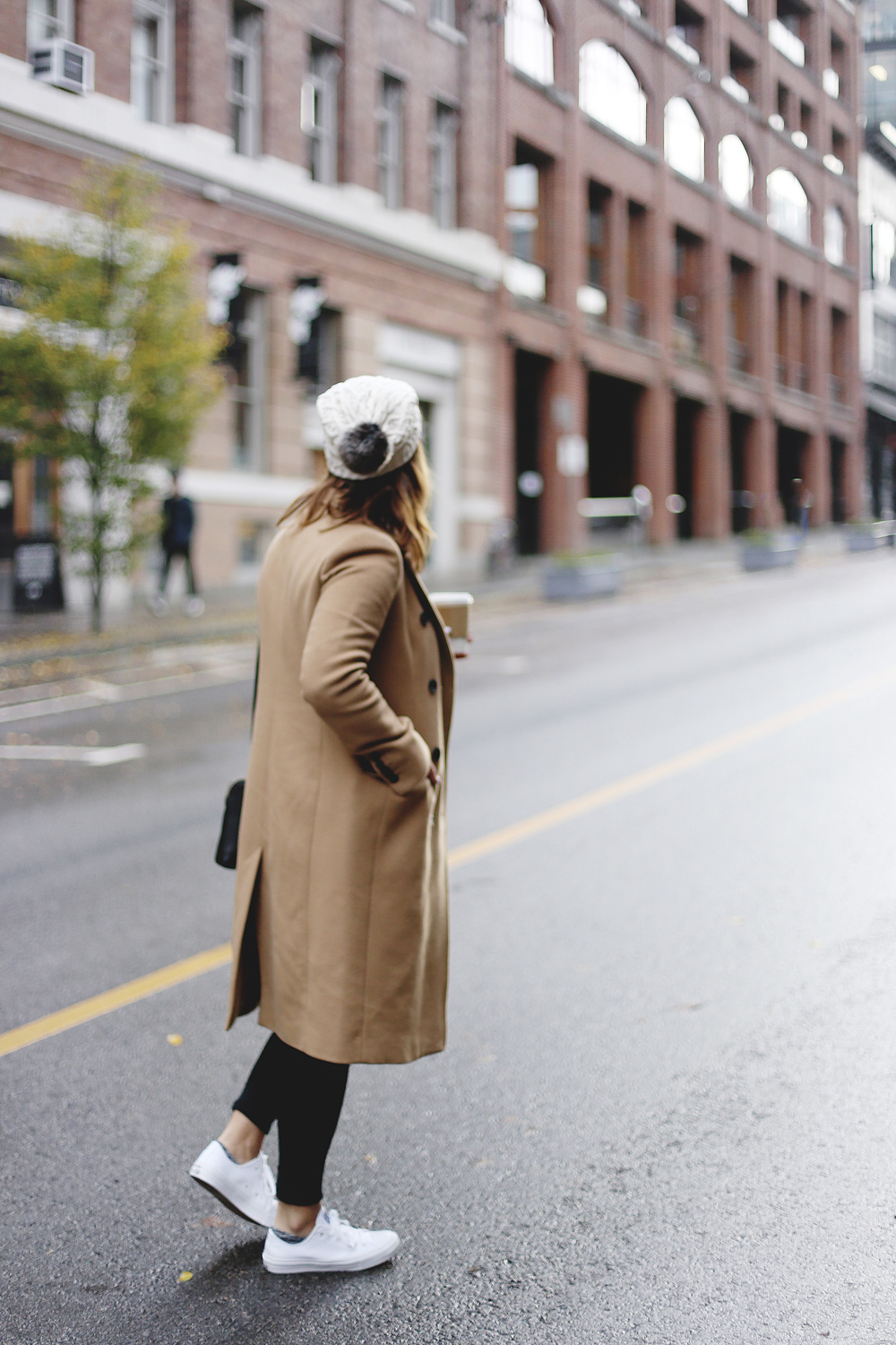 To Vogue or Bust shares ways to style your converse sneakers in white Converse All Stars, Aritzia camel coat, James Jeans black skinny jeans, Aritzia black leather bag and a Tilley Hats beanie