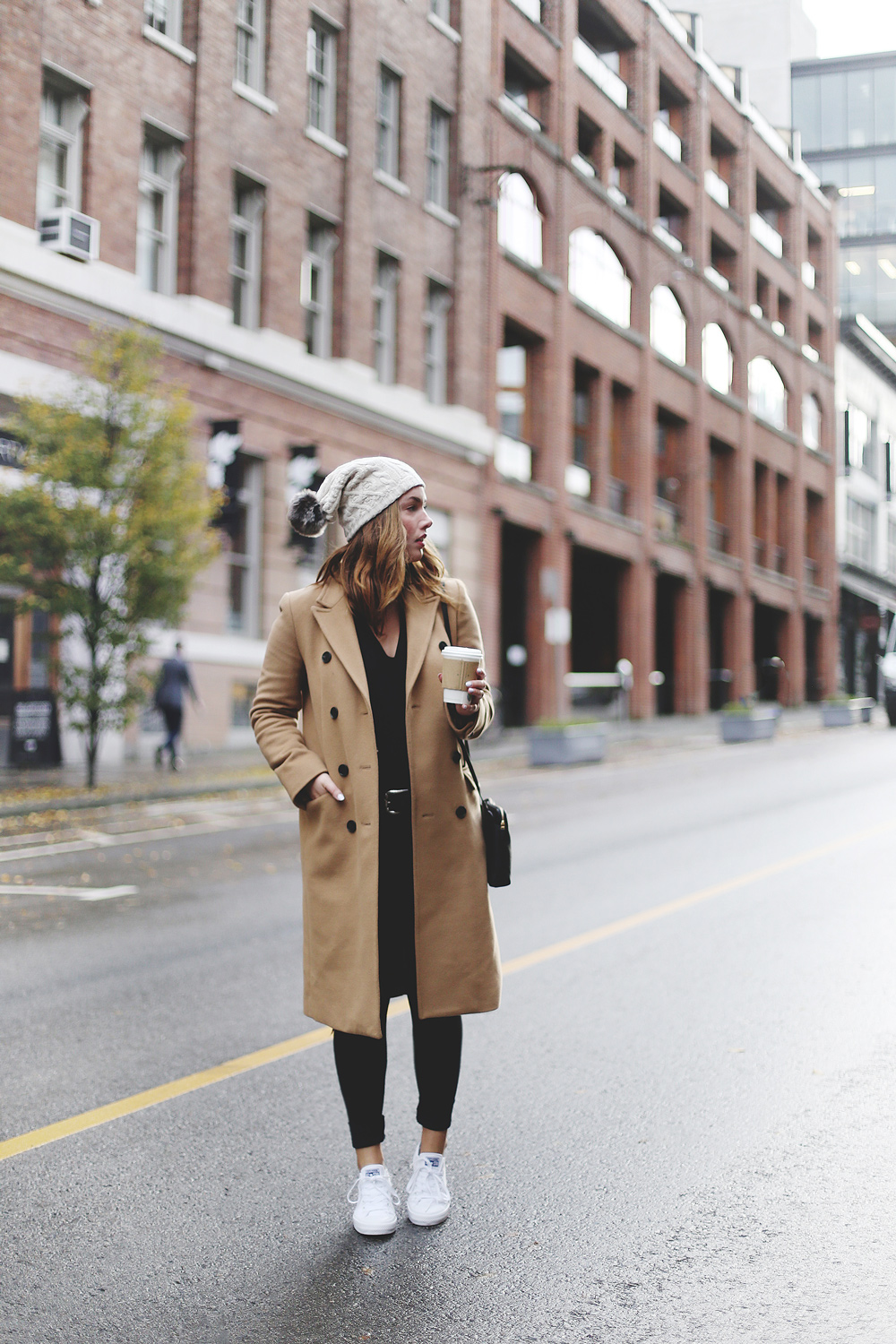 To Vogue or Bust shares ways to style your converse sneakers in white Converse All Stars, Aritzia camel coat, James Jeans black skinny jeans, Aritzia black leather bag and a Tilley Hats beanie