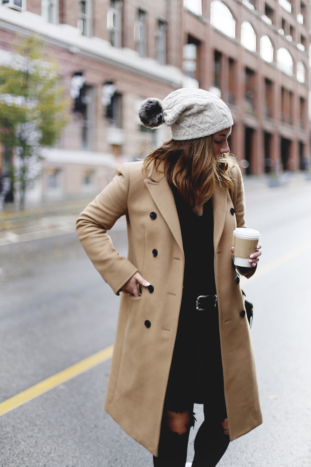 To Vogue or Bust shares ways to style your converse sneakers in white Converse All Stars, Aritzia camel coat, James Jeans black skinny jeans, Aritzia black leather bag and a Tilley Hats beanie