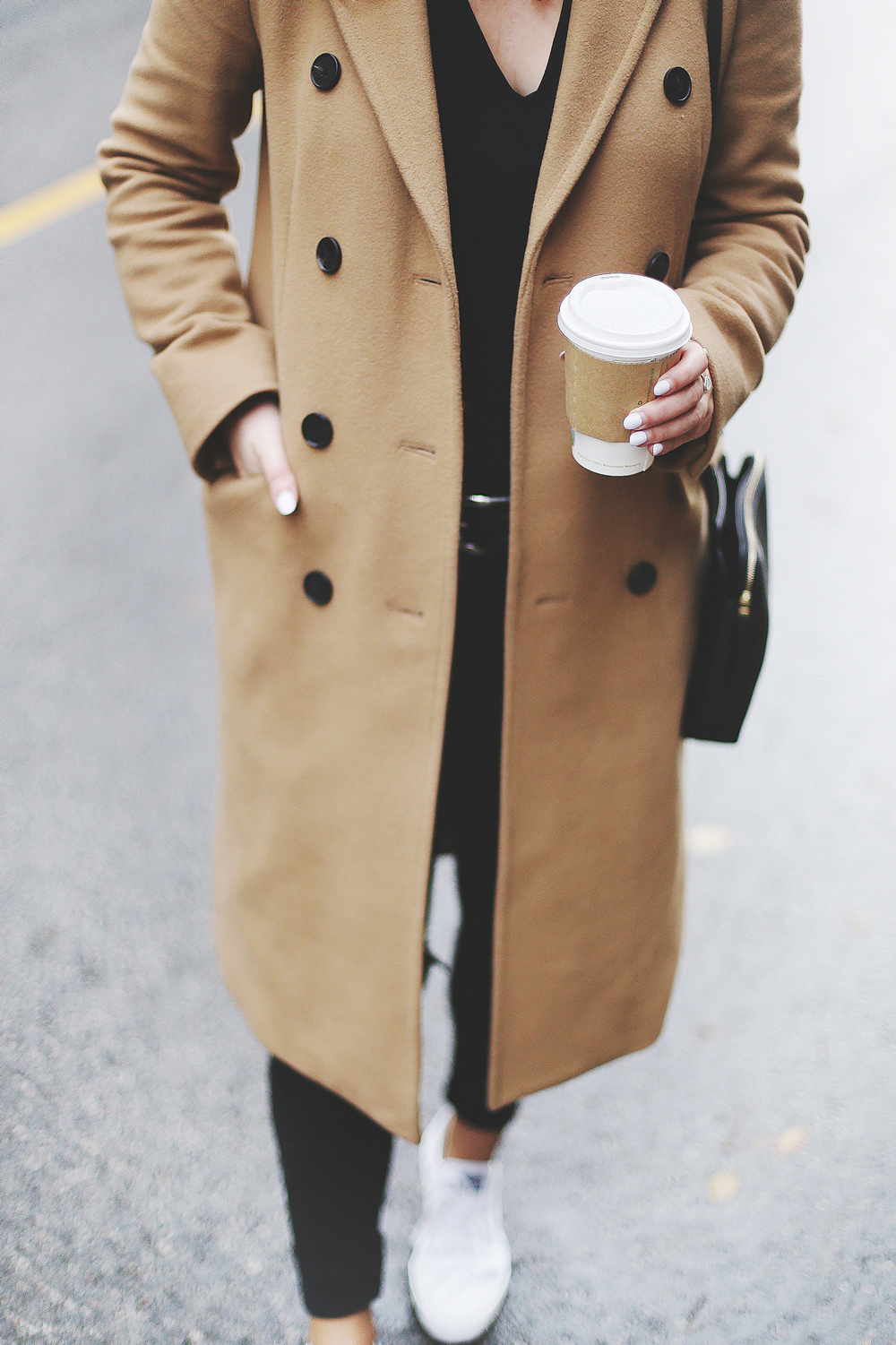 To Vogue or Bust shares ways to style your converse sneakers in white Converse All Stars, Aritzia camel coat, James Jeans black skinny jeans, Aritzia black leather bag and a Tilley Hats beanie