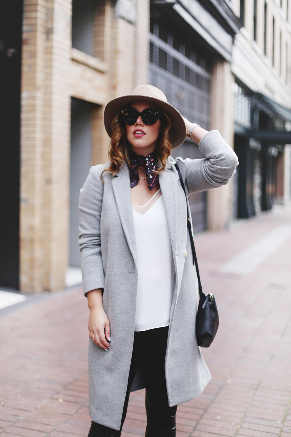 Legging leather outfit tips in Aritzia leather leggings, Aritzia silk camisole, Aritzia wool grey coat, Express tan fedora, Aritzia silk scarf, Aritzia black leather bag, CLUSE mesh silver watch and Urban Outfitters suede ankle boots styled by To Vogue or Bust