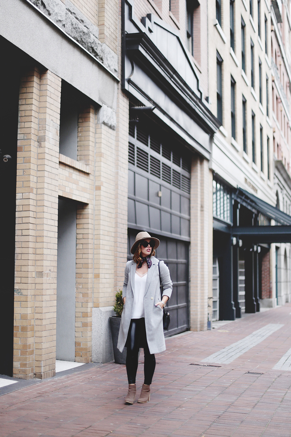 Leather legging outfit tips in Aritzia leather leggings, Aritzia silk camisole, Aritzia wool grey coat, Express tan fedora, Aritzia silk scarf, Aritzia black leather bag, CLUSE mesh silver watch and Urban Outfitters suede ankle boots styled by To Vogue or Bust