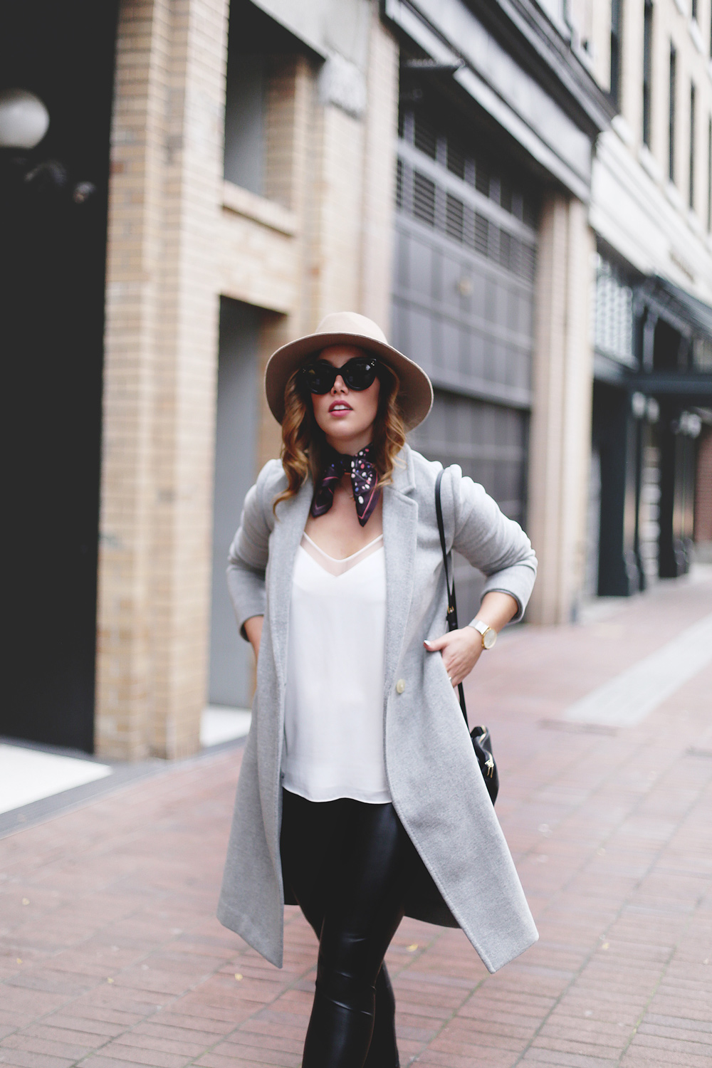 Legging leather outfit tips in Aritzia leather leggings, Aritzia silk camisole, Aritzia wool grey coat, Express tan fedora, Aritzia silk scarf, Aritzia black leather bag, CLUSE mesh silver watch and Urban Outfitters suede ankle boots styled by To Vogue or Bust