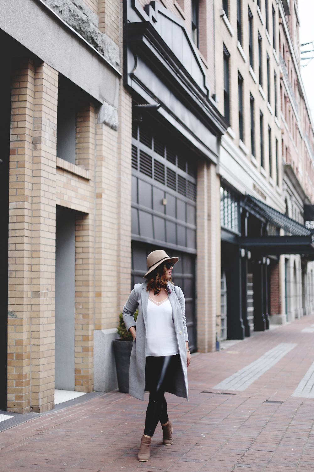 Legging leather outfit tips in Aritzia leather leggings, Aritzia silk camisole, Aritzia wool grey coat, Express tan fedora, Aritzia silk scarf, Aritzia black leather bag, CLUSE mesh silver watch and Urban Outfitters suede ankle boots styled by To Vogue or Bust