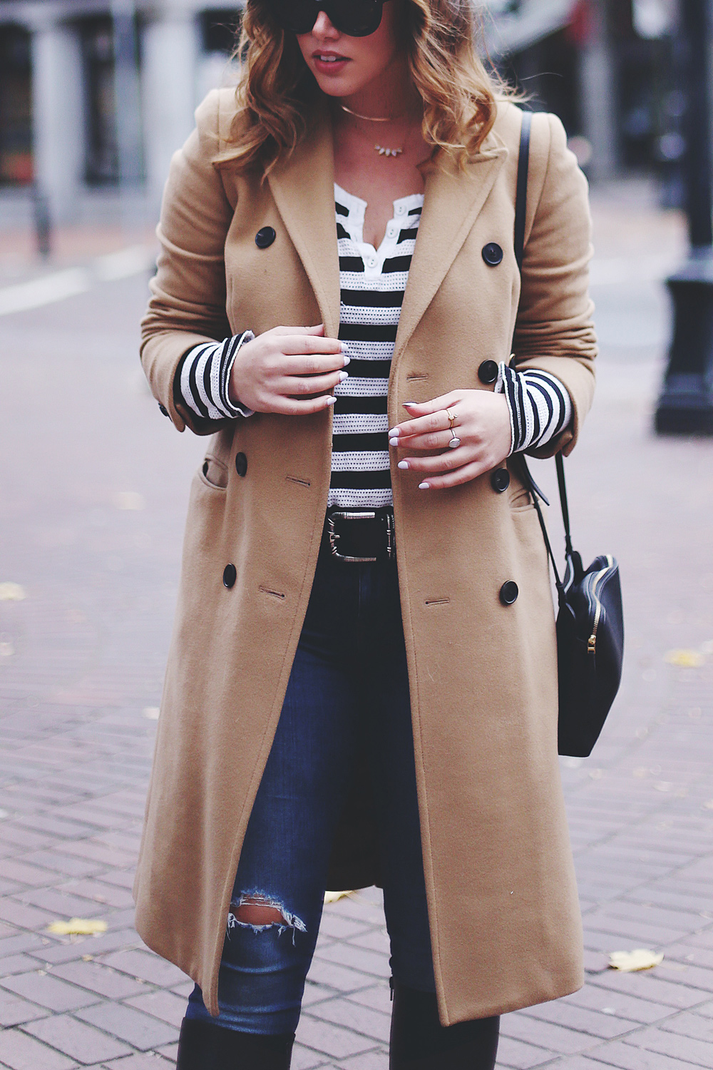 To Vogue or Bust shares camel coat outfit ideas in a camel Aritzia wilfred coat, Mavi skinny jeans, striped Gentle Fawn top, La Canadienne boots and Celine sunglasses in Gastown, Vancouver