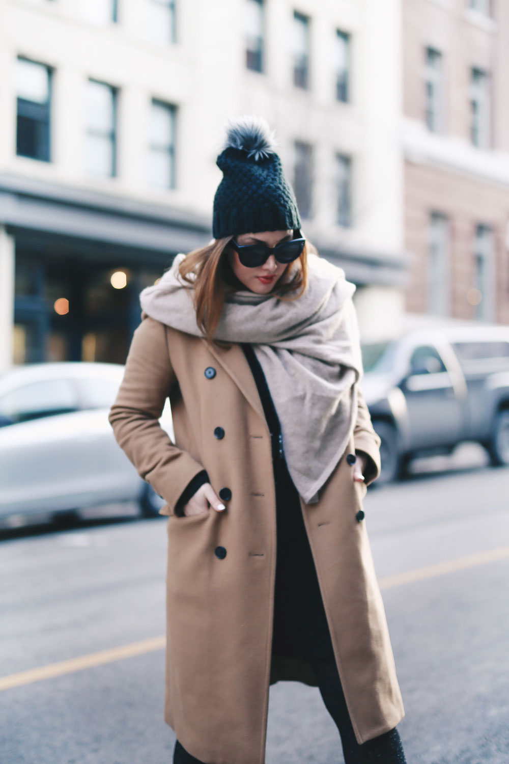 Tips on wearing a dress in the winter styled by To Vogue or Bust in an Aritzia camel wool coat, White and Warren cashmere dress, White and Warren cashmere travel wrap, Frye ankle boots, Express beanie hat and Celine Caty sunglasses
