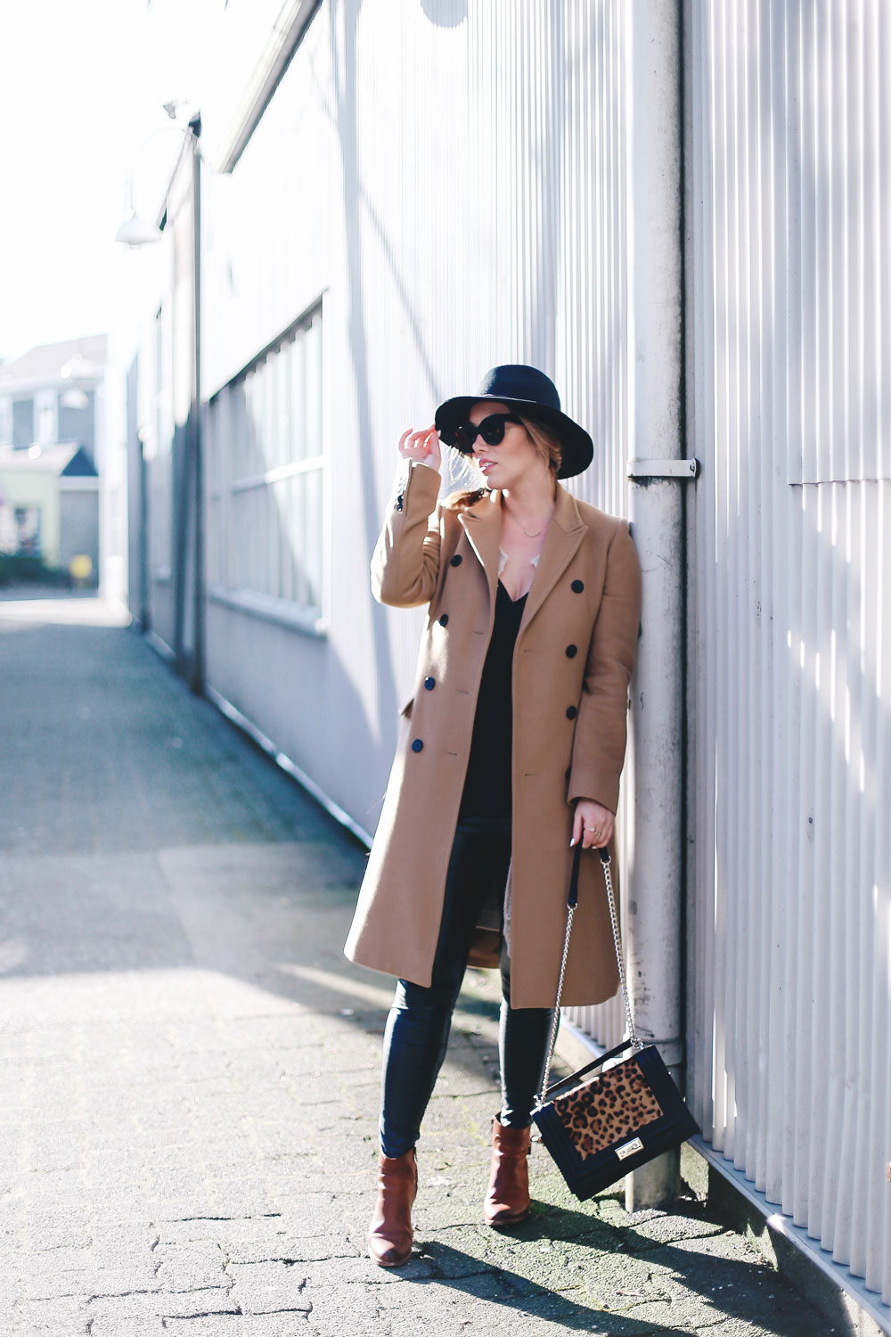 Best winter to spring transition piece in a camel wool coat, leather leggings, leopard cross body bag, statement vest and wool fedora