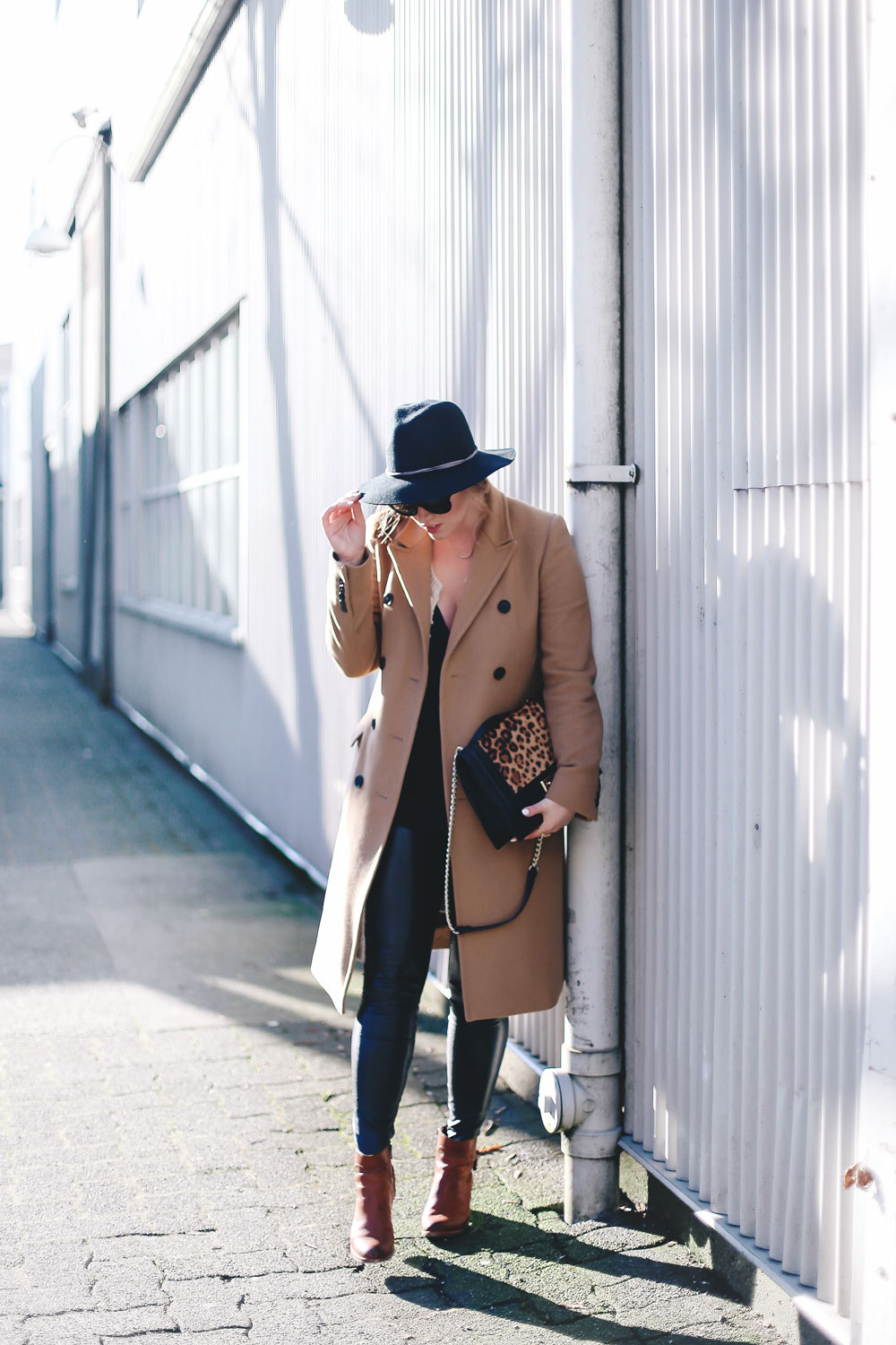 Best winter to spring transition piece in a camel wool coat, leather leggings, leopard cross body bag, statement vest and wool fedora