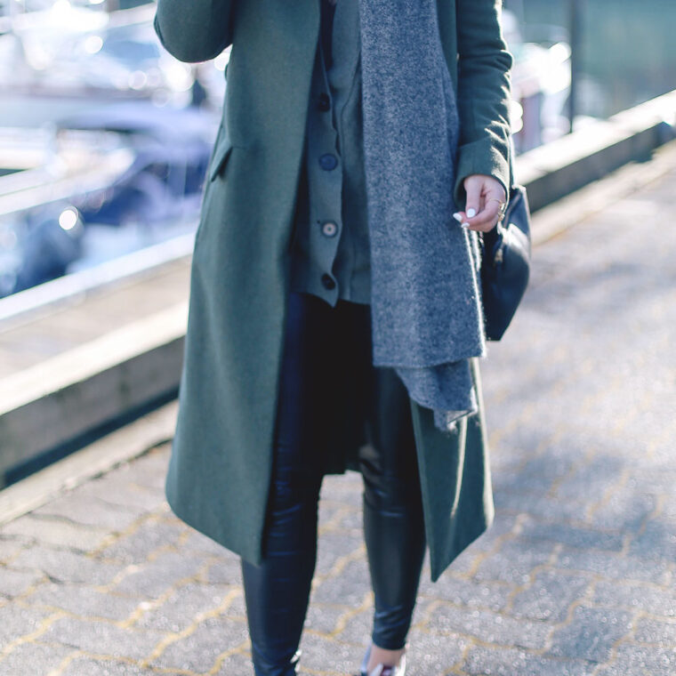 Tips to style sneakers in New Balance sneakers, a statement green coat, leather leggings and cashmere cardigan