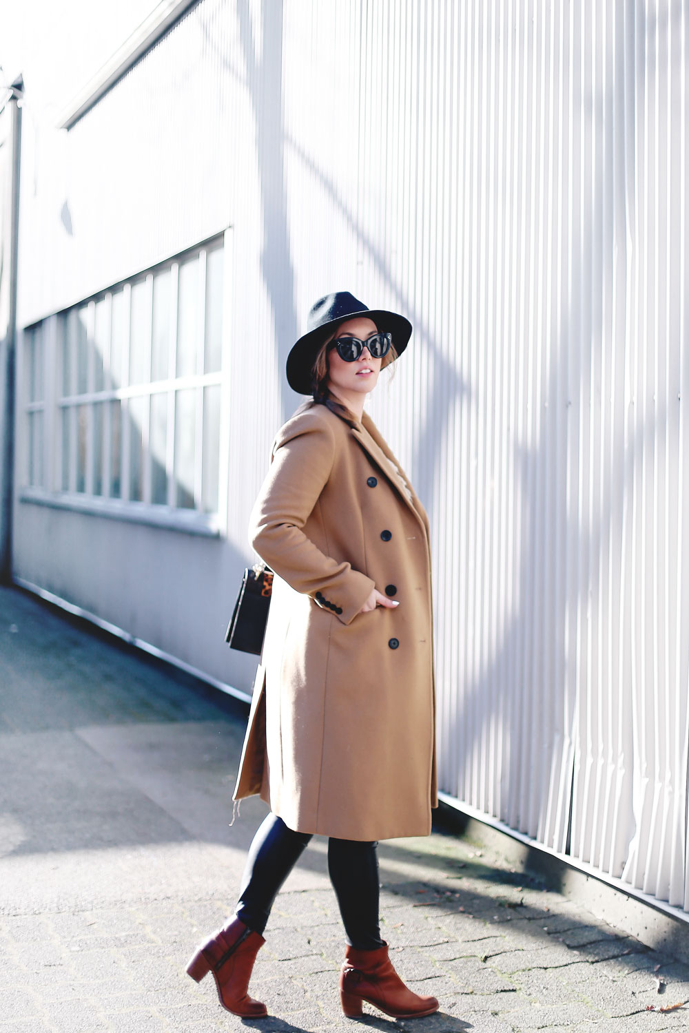 Best winter to spring transition piece in a camel wool coat, leather leggings, leopard cross body bag, statement vest and wool fedora