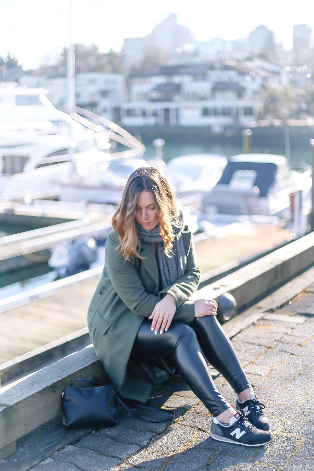 Tips to style sneakers in New Balance sneakers, a statement green coat, leather leggings and cashmere cardigan