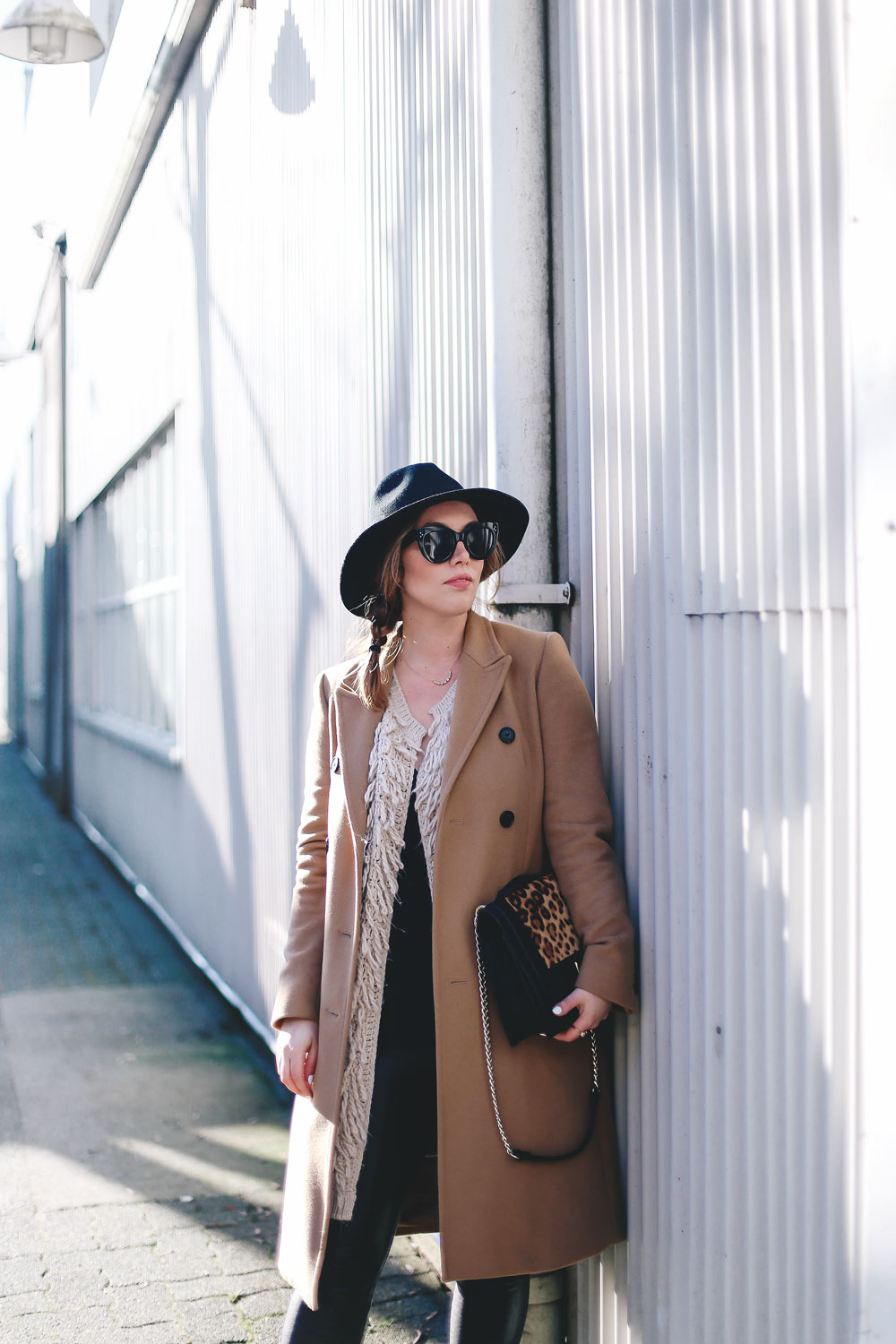 Best winter to spring transition piece in a camel wool coat, leather leggings, leopard cross body bag, statement vest and wool fedora