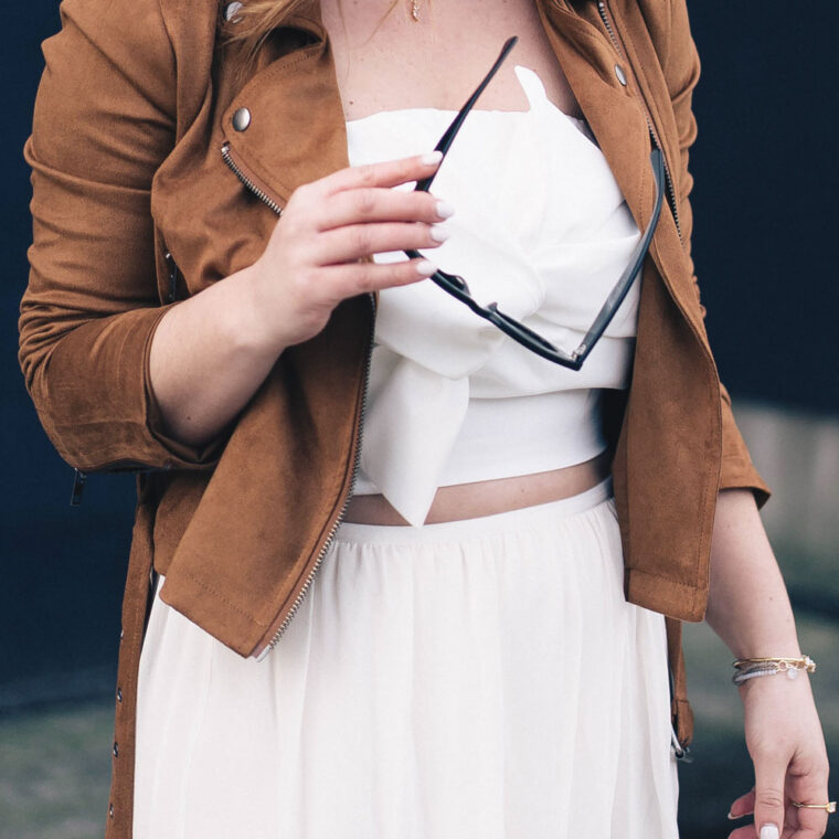 Western trend style tips in Lovers + Friends suede jacket, Revolve clothing, Aritzia skirt, Chicwish cropped top, Raye heels, Bega bag, Leah Alexandra jewelry, Celine sunglasses styled by To Vogue or Bust