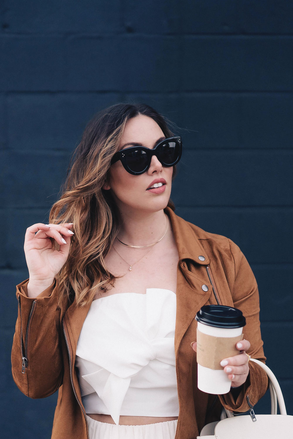 Western trend style tips in Lovers + Friends suede jacket, Revolve clothing, Aritzia skirt, Chicwish cropped top, Raye heels, Bega bag, Leah Alexandra jewelry, Celine sunglasses styled by To Vogue or Bust