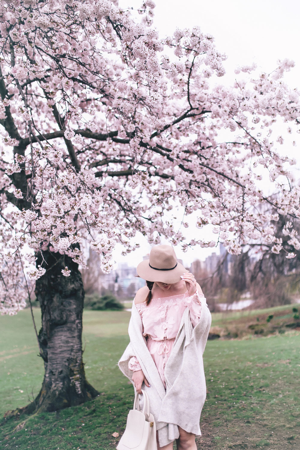 How to style off the shoulder spring trend in Revolve dress, Express wool fedora, Leah Alexandra jewellery, Revolve strapless dress, Mavi Coatigan, Lovers and Friends dress, how to wear strapless, cherry blossoms in Vancouver by To Vogue or Bust 