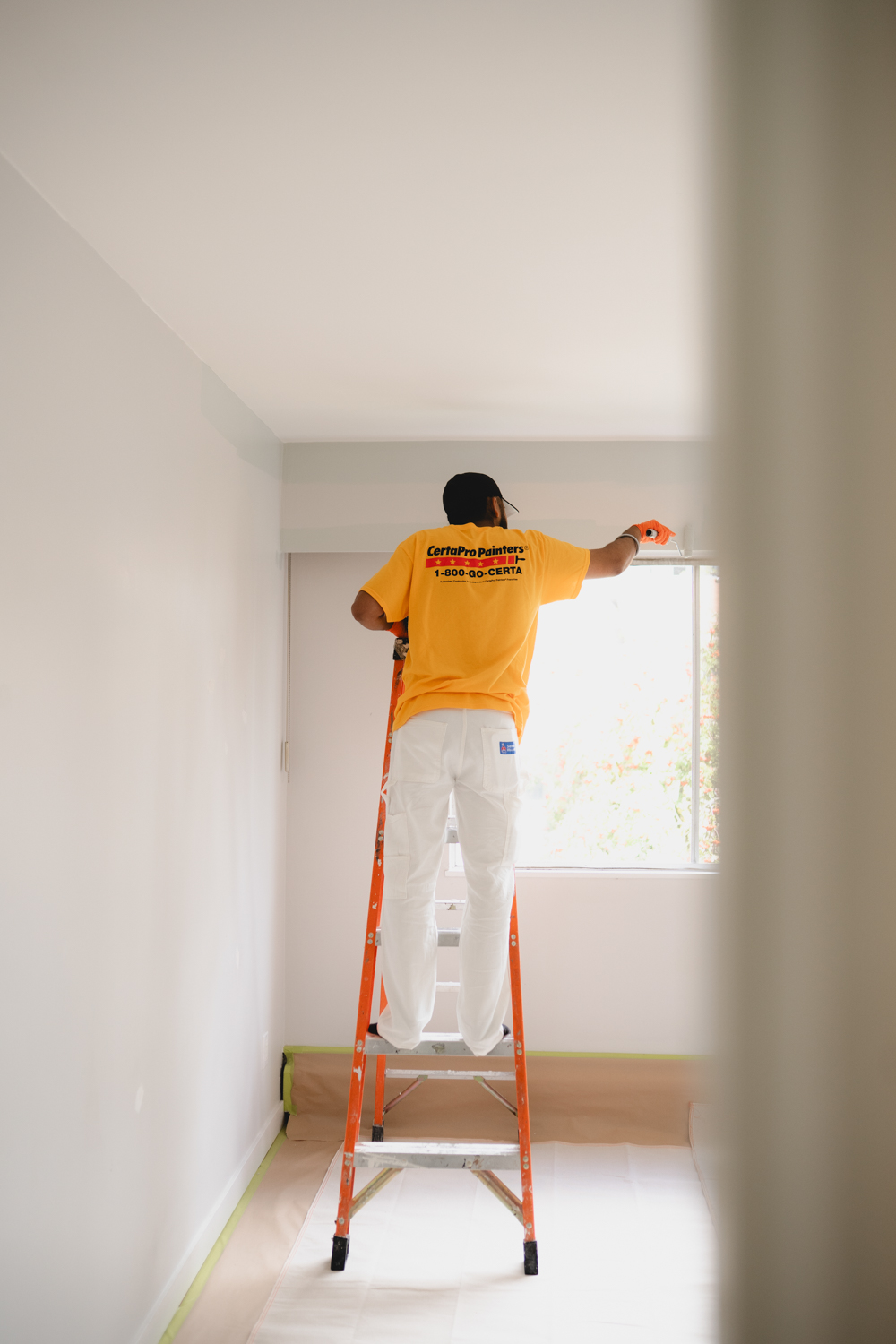 CertaPro painter working from a ladder during an interior painting project in Vancouver