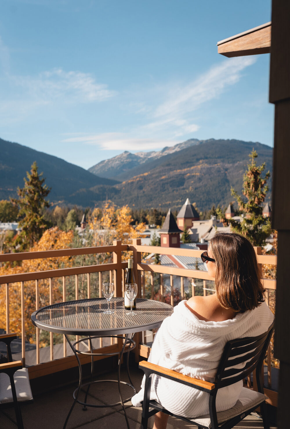 Woman enjoying the mountain view from a balcony at Pan Pacific Whistler Village Centre