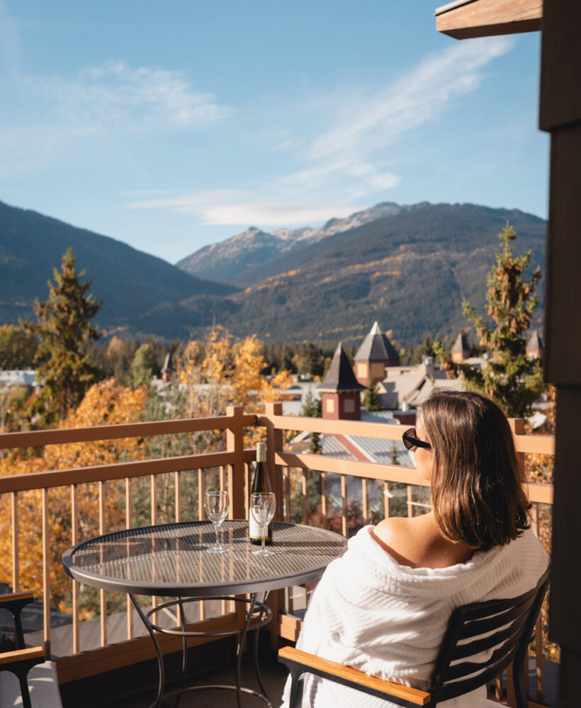 Woman enjoying the mountain view from a balcony at Pan Pacific Whistler Village Centre