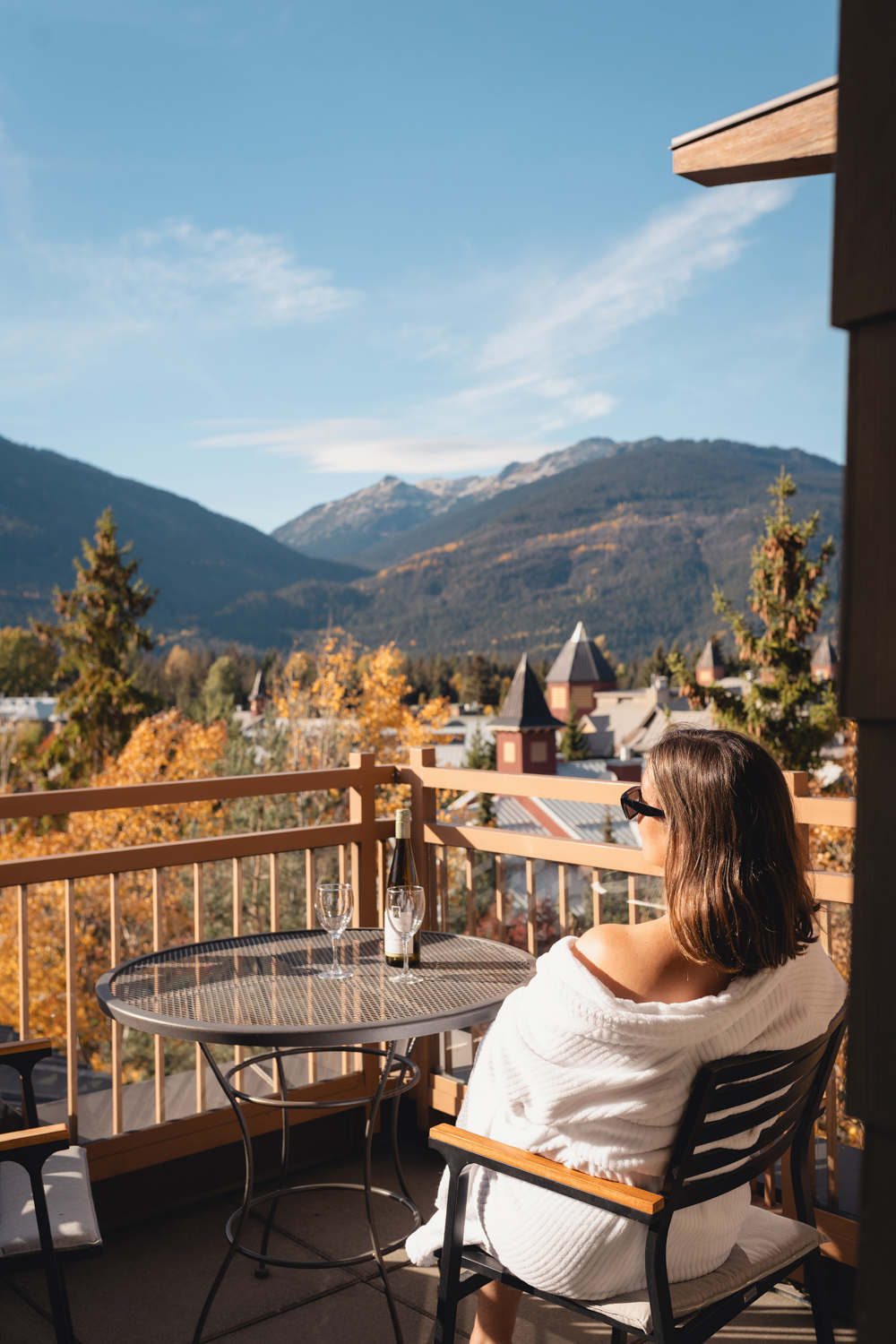 Woman enjoying the mountain view from a balcony at Pan Pacific Whistler Village Centre